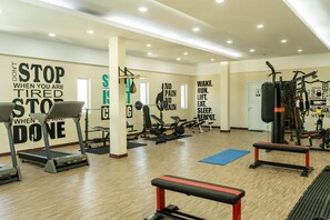Ein Fitnessstudio mit Laufbändern, Krafttrainingsgeräten und motivierenden Plakaten an den Wänden.