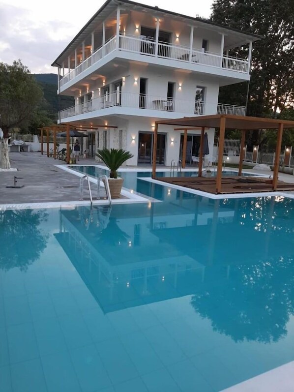 Un edificio de dos pisos con una piscina delantera.
