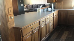 Eine Küche mit Holzschränken, einer Arbeitsplatte und einem eingebauten Backofen.