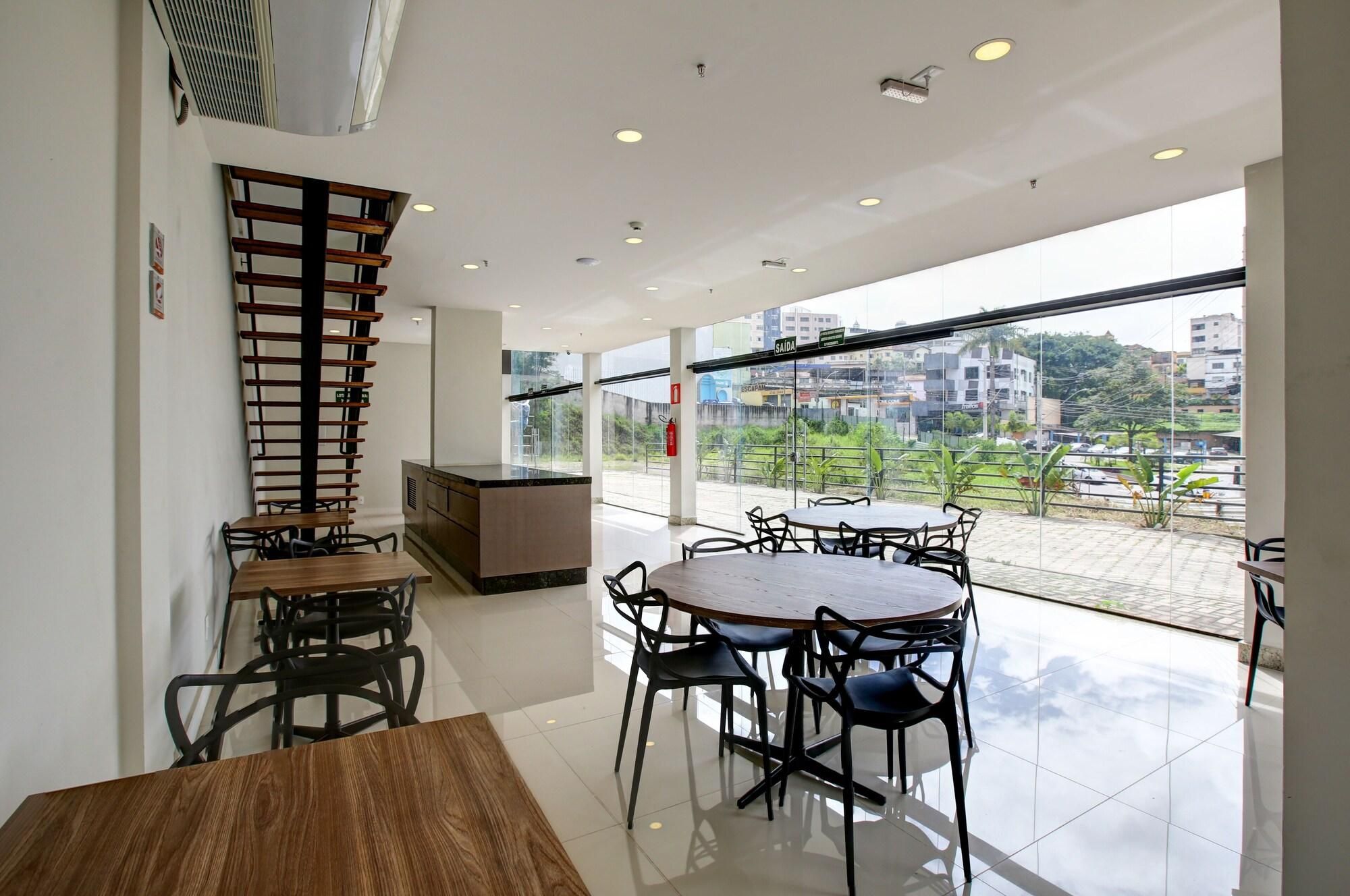 A modern interior with a dining area, a kitchen, and a balcony with a city view.