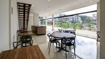 A modern interior with a dining area, a kitchen, and a balcony with a city view.