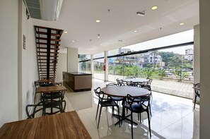 A modern interior with a dining area, a kitchen, and a balcony with a city view.