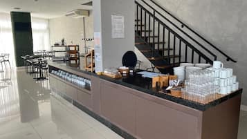 A clean, modern breakfast area with a counter, seating, and a staircase.