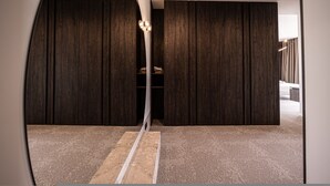 Ein Zimmer mit dunklen Holzpaneelen, einem weißen Boden und einer zentralen Leuchte.