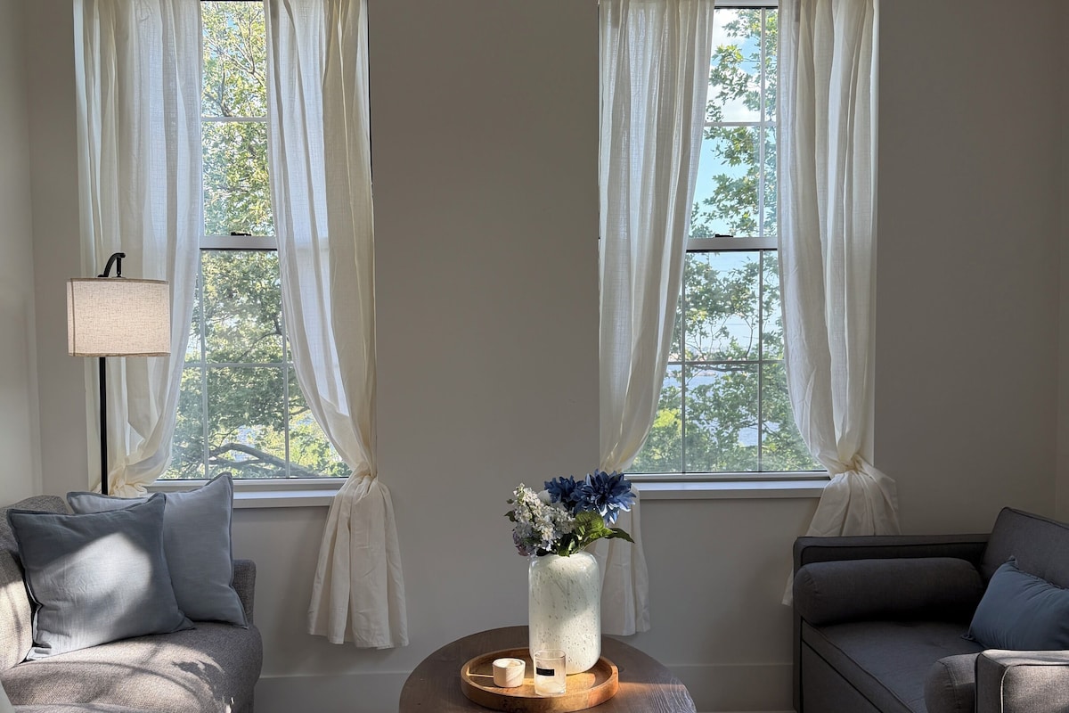 A living room with two sofas, a coffee table with a vase, and a lamp.