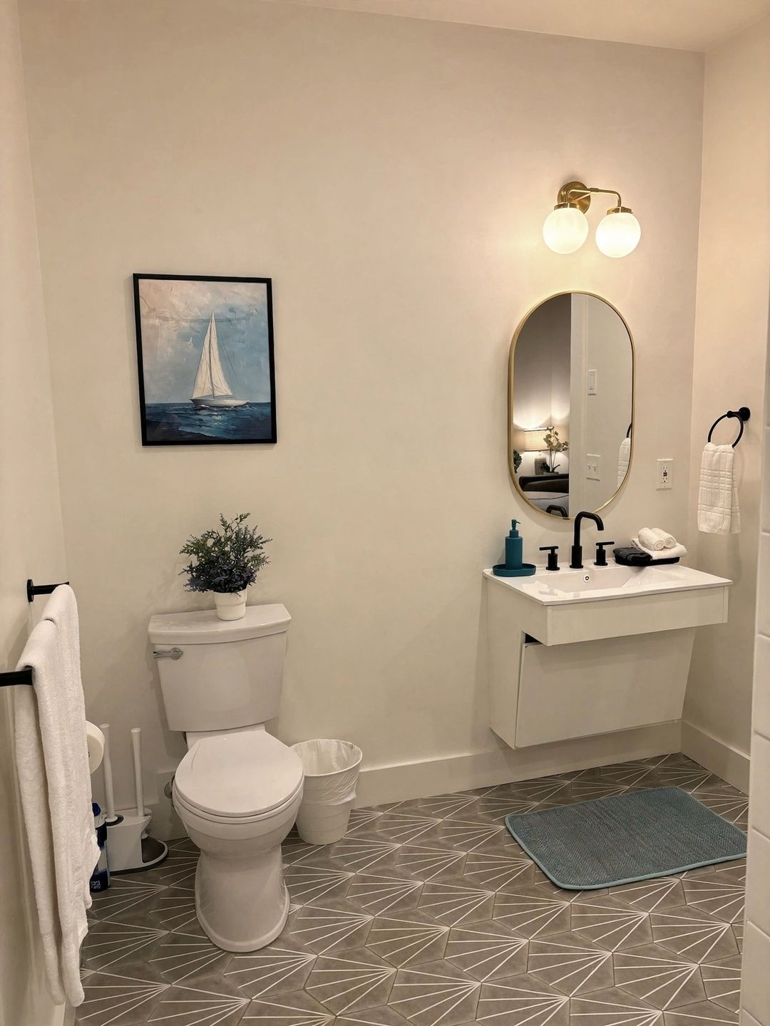 Ein Badezimmer mit Toilette, Waschbecken, Spiegel und einem Gemälde eines Segelboots.