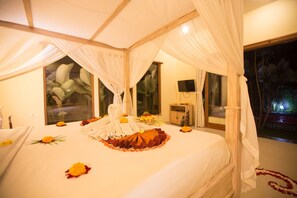 A room with a bed, a TV, and a view of the outdoors. - Asri Sari Resort Ubud (Ubud)