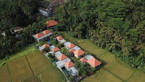 An aerial view of a resort with multiple buildings, each with a red roof, surrounded by lush greenery and rice paddies. - Asri Sari Resort Ubud (Ubud)