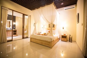 A bedroom with a bed, a nightstand, a mirror, and a sliding door. - Asri Sari Resort Ubud (Ubud)