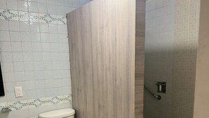 A bathroom with a toilet, sink, and shower area.
