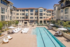 A rooftop pool area with lounge chairs, a pool, and a building with multiple floors and balconies. - Locale Menlo Park (Menlo Park)