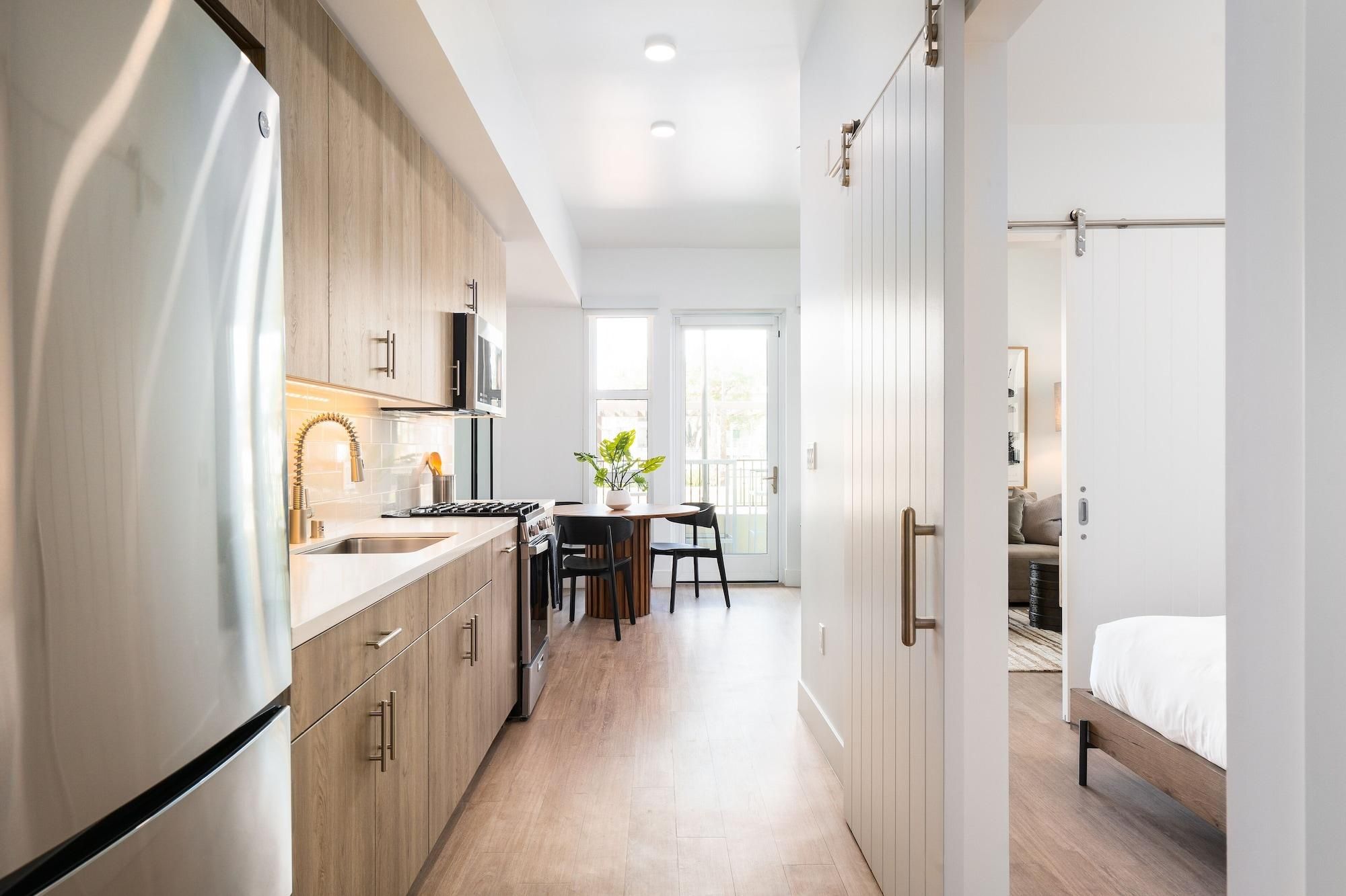 A modern kitchen with a built-in oven, microwave, and stainless steel refrigerator.