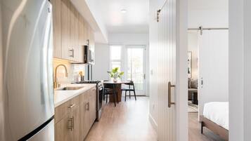 A modern kitchen with a built-in oven, microwave, and stainless steel refrigerator.