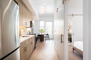 A modern kitchen with a built-in oven, microwave, and stainless steel refrigerator.