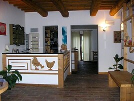 Una cocina con una isla de madera, un área de comedor con un banco y un pasillo que lleva a una puerta.