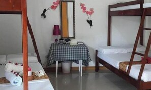 A room with two bunk beds, a small table with a checkered tablecloth, a lamp, and decorative flowers on the wall. - Hanbee S Resort (Puerto Princesa)