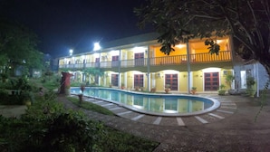 A two-story building with a swimming pool, surrounded by greenery. - Hanbee S Resort (Puerto Princesa)