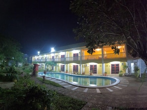 A two-story building with a swimming pool, surrounded by greenery. - Hanbee S Resort (Puerto Princesa)