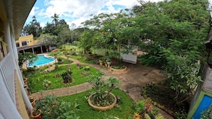 A rooftop garden with a swimming pool, various potted plants, and a view of surrounding buildings. - Hanbee S Resort (Puerto Princesa)