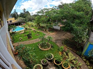 A rooftop garden with a swimming pool, various potted plants, and a view of surrounding buildings. - Hanbee S Resort (Puerto Princesa)
