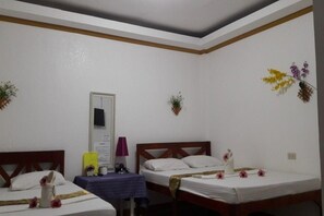 A room with two beds, a small table, and decorative wall plants. - Hanbee S Resort (Puerto Princesa)