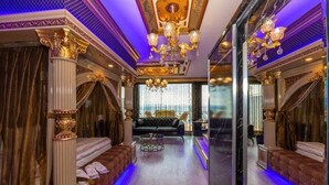 A luxurious room with a grand chandelier, ornate columns, and a plush sofa. - By Mesut Resa Dence (Istanbul)