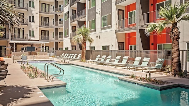 A multi-story hotel with a swimming pool, outdoor seating, and palm trees. - Locale Midtown Phoenix (Phoenix)