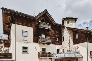 Un edificio de varios pisos con balcones de madera y una torre de piedra.