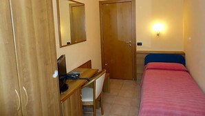 A room with a bed, a desk with a chair, a wardrobe, a door, and a wall-mounted light. - Hotel Adler (Menaggio)