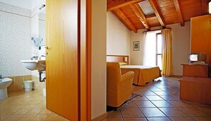 A room with a bed, a television, and a bathroom with a sink and toilet. - Hotel Alla Nave (Masi)