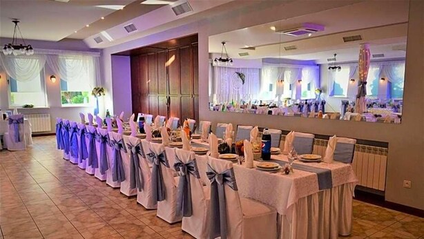 A banquet hall with rows of tables, chairs, and a large mirror reflecting the room. - Hotel Wielkopolanka (Środa Wielkopolska)