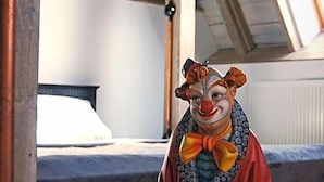 Una habitación con techo inclinado, una cama y una ventana.