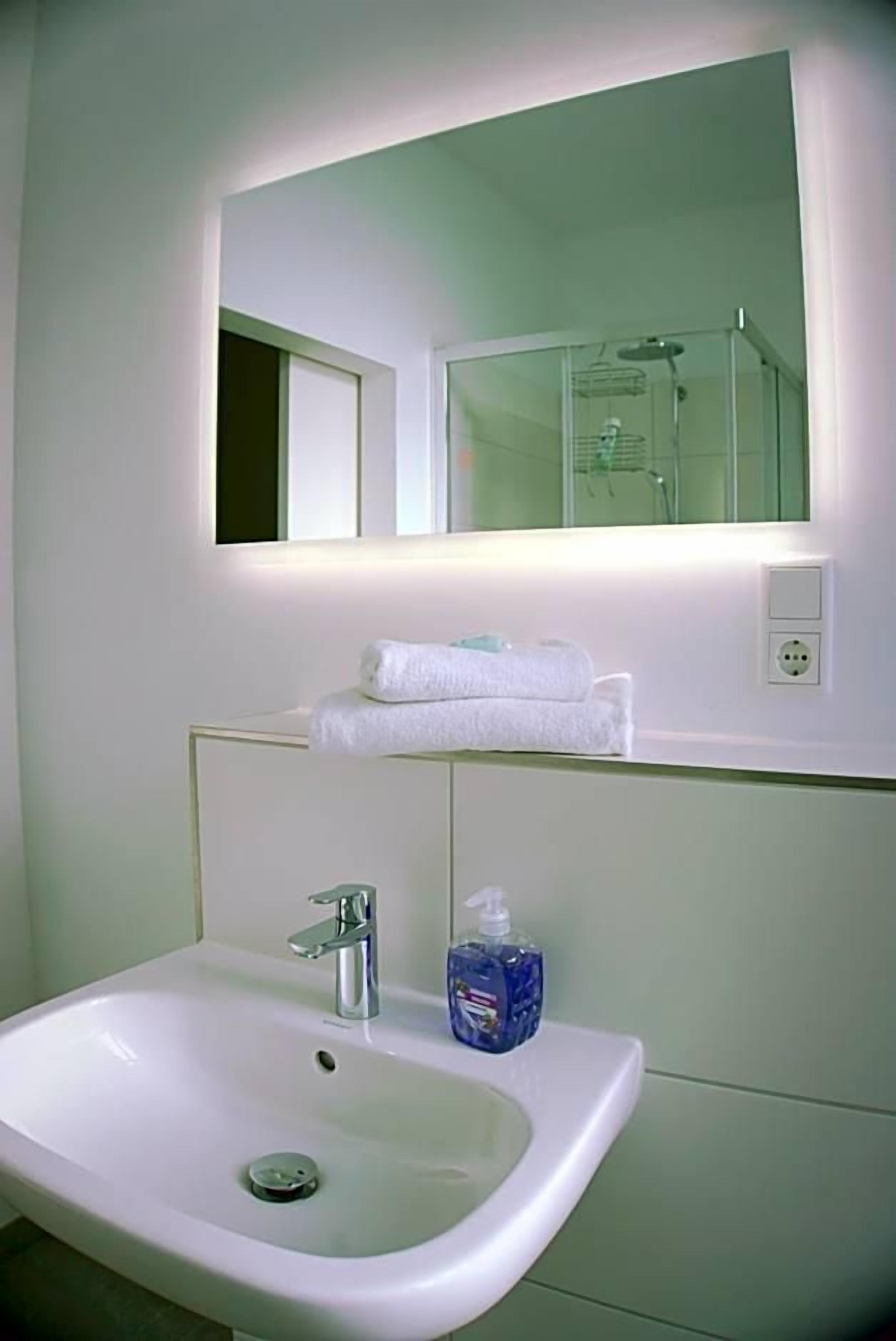 Ein Badezimmer mit Waschbecken, Spiegel und Handtuchhalter.