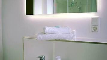 Ein Badezimmer mit Waschbecken, Spiegel und Handtuchhalter.