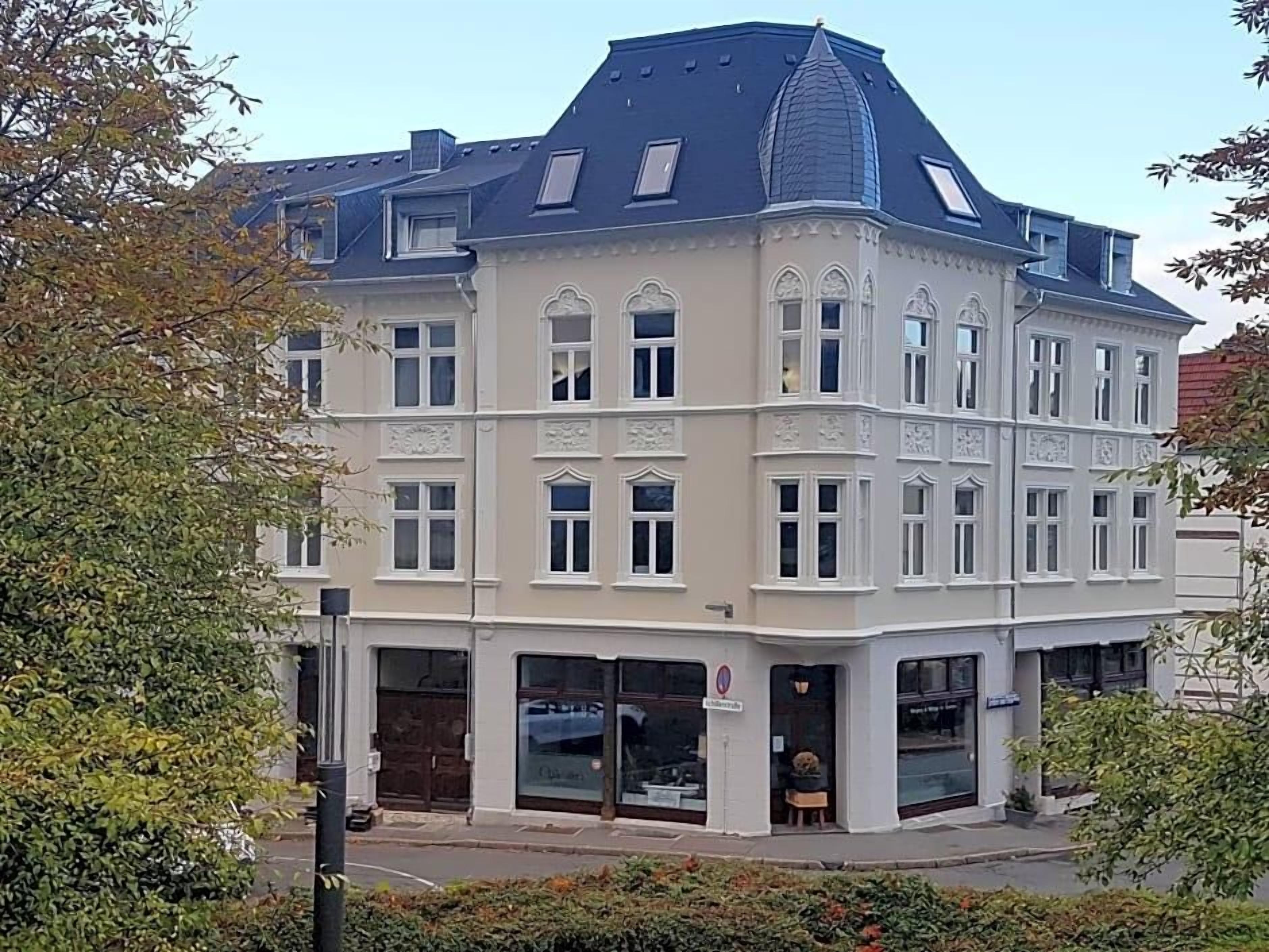 Ein Eckgebäude mit zahlreichen Fenstern und einem markanten architektonischen Stil.