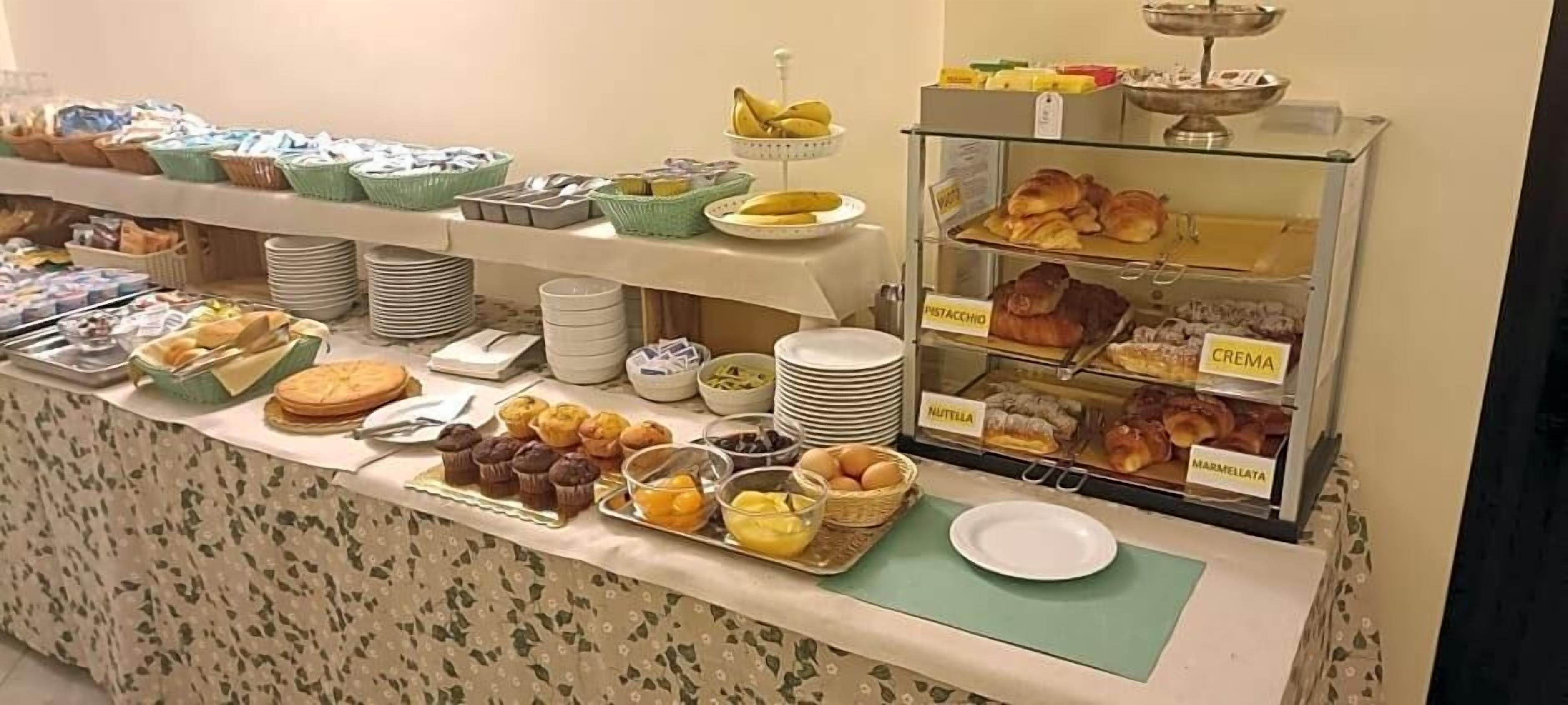 Un buffet con diversi cibi e sezioni segnalate per pistacchio, crema, Nutella e marmellata.