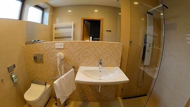 Un baño con inodoro, lavamanos y ducha.