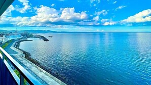 Un paisaje urbano costero con cielo despejado, mar tranquilo y un puente.