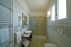 A bathroom with a glass-enclosed shower, a sink with a bowl, a towel rack, and a window. - Hotel Strand A Frontemare (Jesolo)