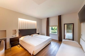 A modern hotel room with a large bed, bedside tables, a desk, and a window with curtains. - Villa I Pini (Civitella in Val di Chiana)