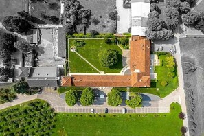 Ilmakuva rakennuksesta, jossa on keskeinen sisäpiha, ja jonka ympärillä on viheralueita ja pysäköintitilaa.