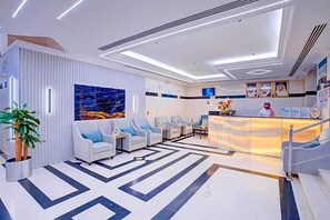 A modern hotel lobby with a reception desk, seating area, and a patterned floor. - Hayah Salam Silver Hotel (Madinah)