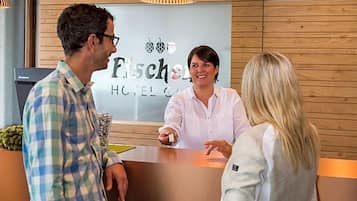 Ein Hotelrezeptionstresen mit Holzvertäfelung, ein Empfangstresen und ein Schild mit dem Namen des Hotels.