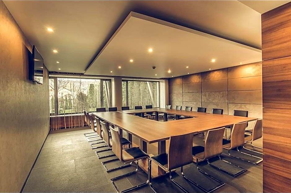 A conference room with a long table, chairs, and large windows.