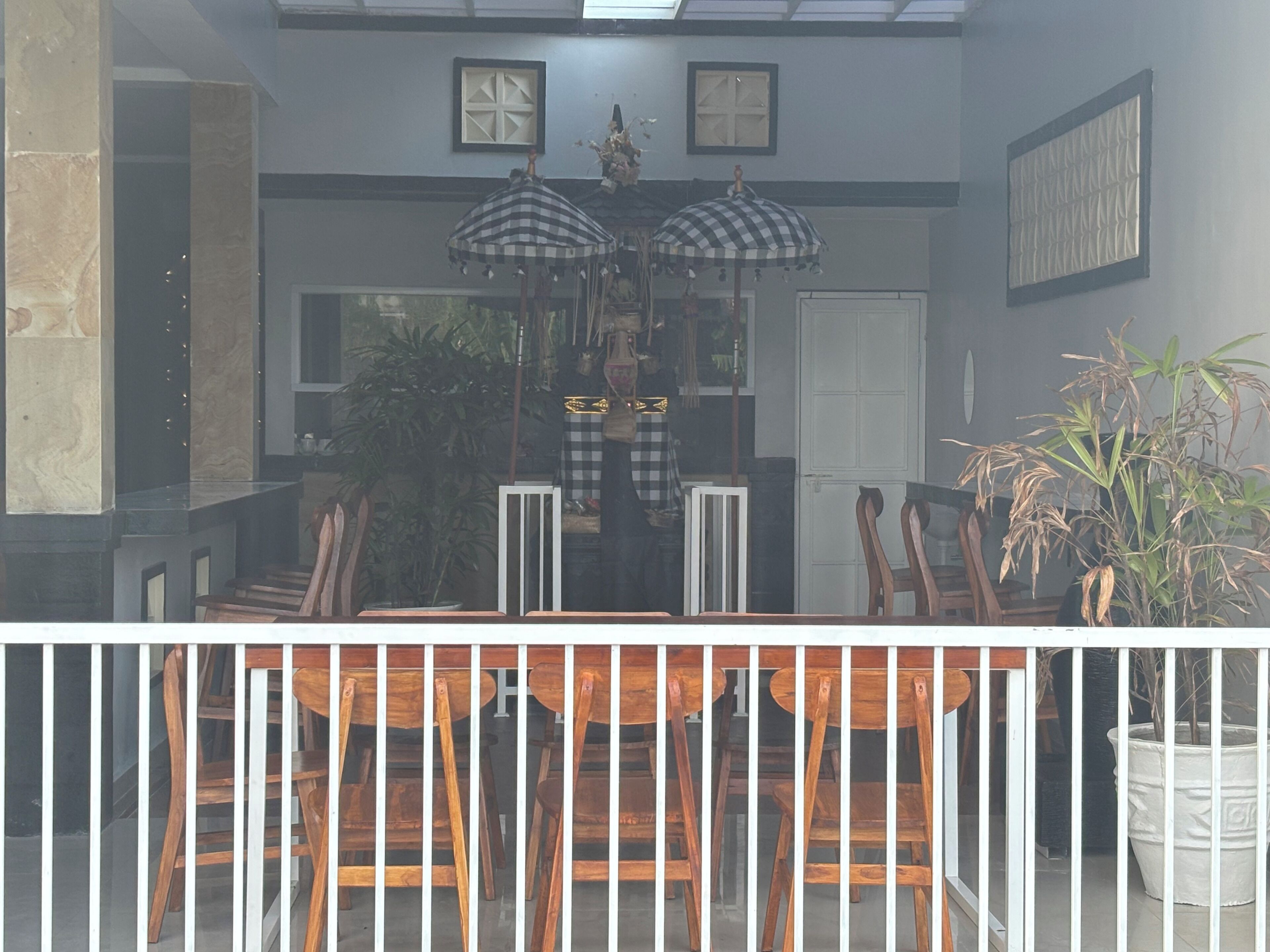 A dining area with a table and chairs, a potted plant, and a decorative umbrella.