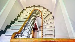 A spiral staircase with a wooden handrail and metal balusters. - Hotel Aida (Florence)