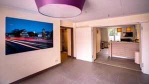 Eine moderne Hotellobby mit einem großen Stadtbild, einem Empfangsbereich und einer Küchenzeile.
