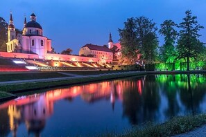 A historic building with a dome and towers, adjacent to a calm water body. - Hotel Prinz Albrecht (Neuzelle)