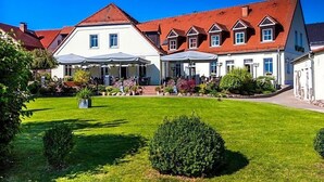 A hotel with a large lawn, multiple buildings, and a red-roofed structure. - Hotel Prinz Albrecht (Neuzelle)