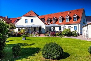 A hotel with a large lawn, multiple buildings, and a red-roofed structure. - Hotel Prinz Albrecht (Neuzelle)